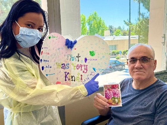 Nurse with patient, holding thank-you cards from children